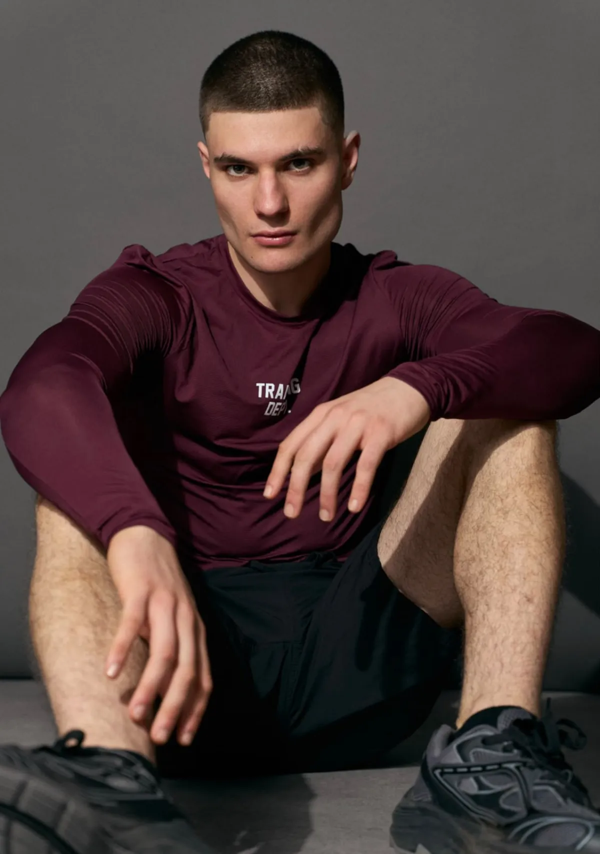 Lutfi Al Fathi seated on the floor in a burgundy long-sleeve top