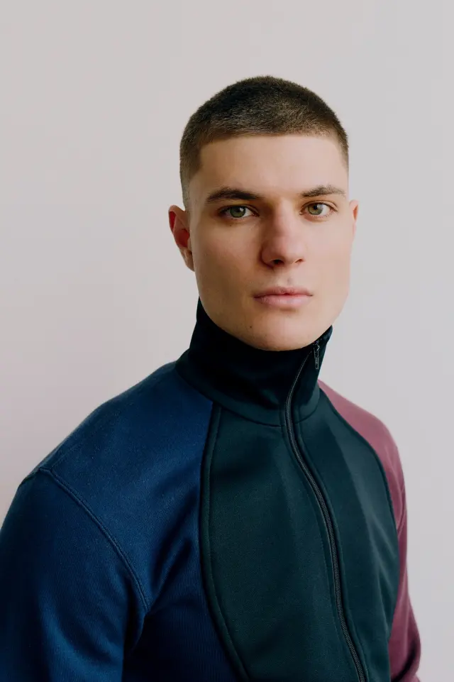 Lutfi Al Fathi in a navy and burgundy zip-neck top, close-up