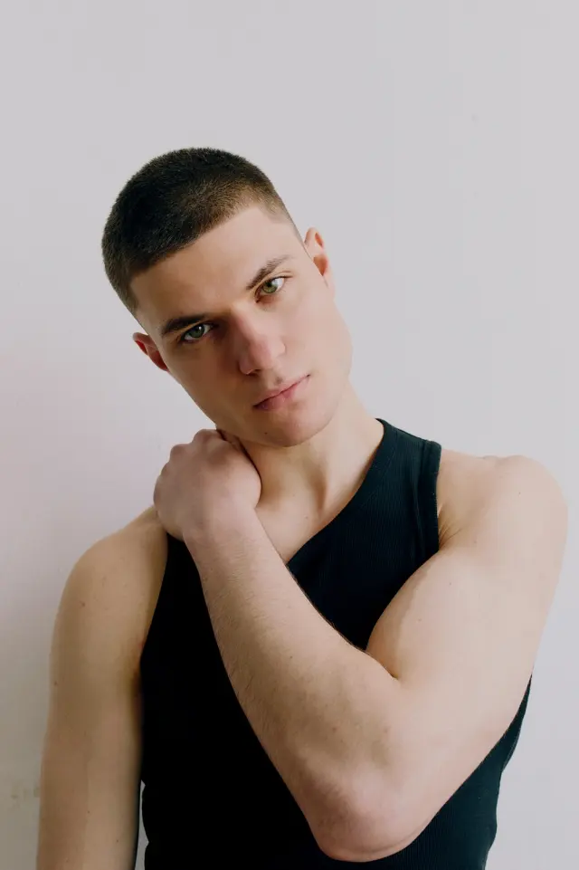 Lutfi Al Fathi in a black tank top with a hand at the neck