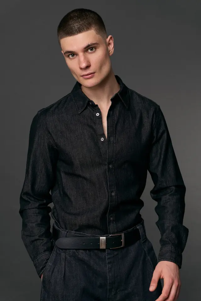 Lutfi Al Fathi in a black denim shirt and belt, studio portrait