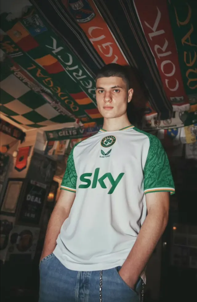 Lutfi Al Fathi in a white and green Ireland football shirt inside a pub